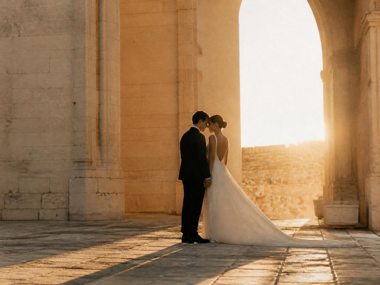 Couple at golden hour in a stone courtyard on their wedding day